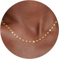 Fine flat mirror-link chain necklace worn at the collarbone
