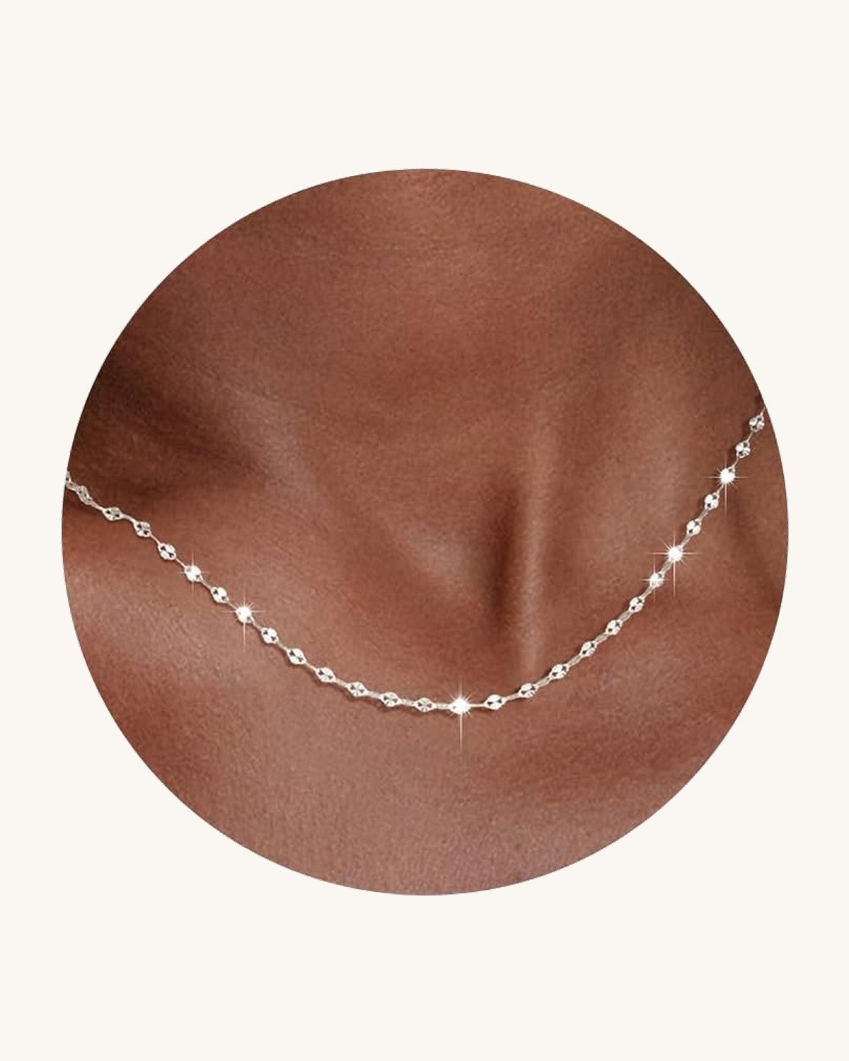 Fine flat mirror-link chain necklace worn at the collarbone
